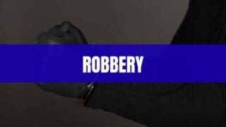 Text that says Robbery on a blue rectangle with a robber's hand in handcuffs in the background